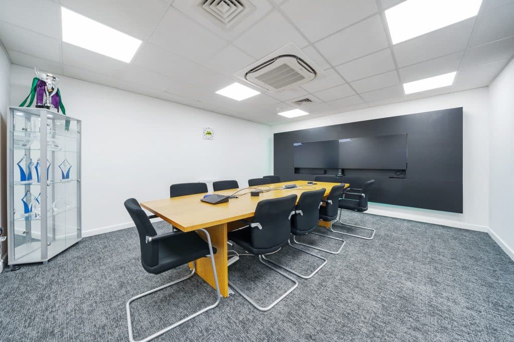 internal office space large meeting room with chairs and table and screen