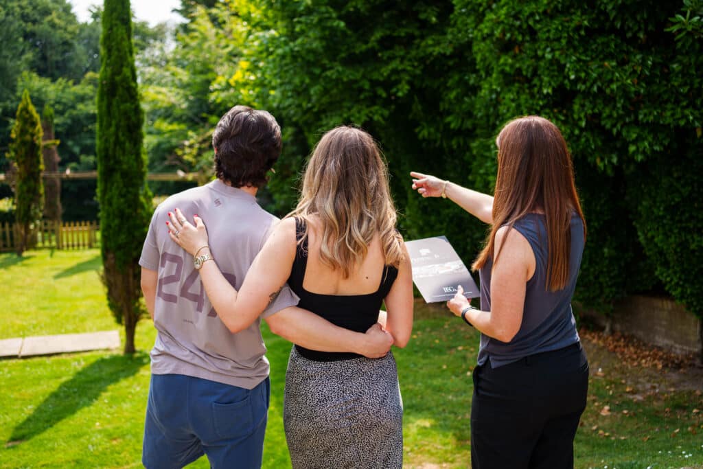 viewinng in Kent, man and woman looking at a property and estate agent explaining the details of the property